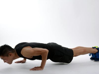 Athletic man doing a pushup movement focus on hands.
