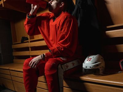 Close up of sports equipment and water bottle on a bench.